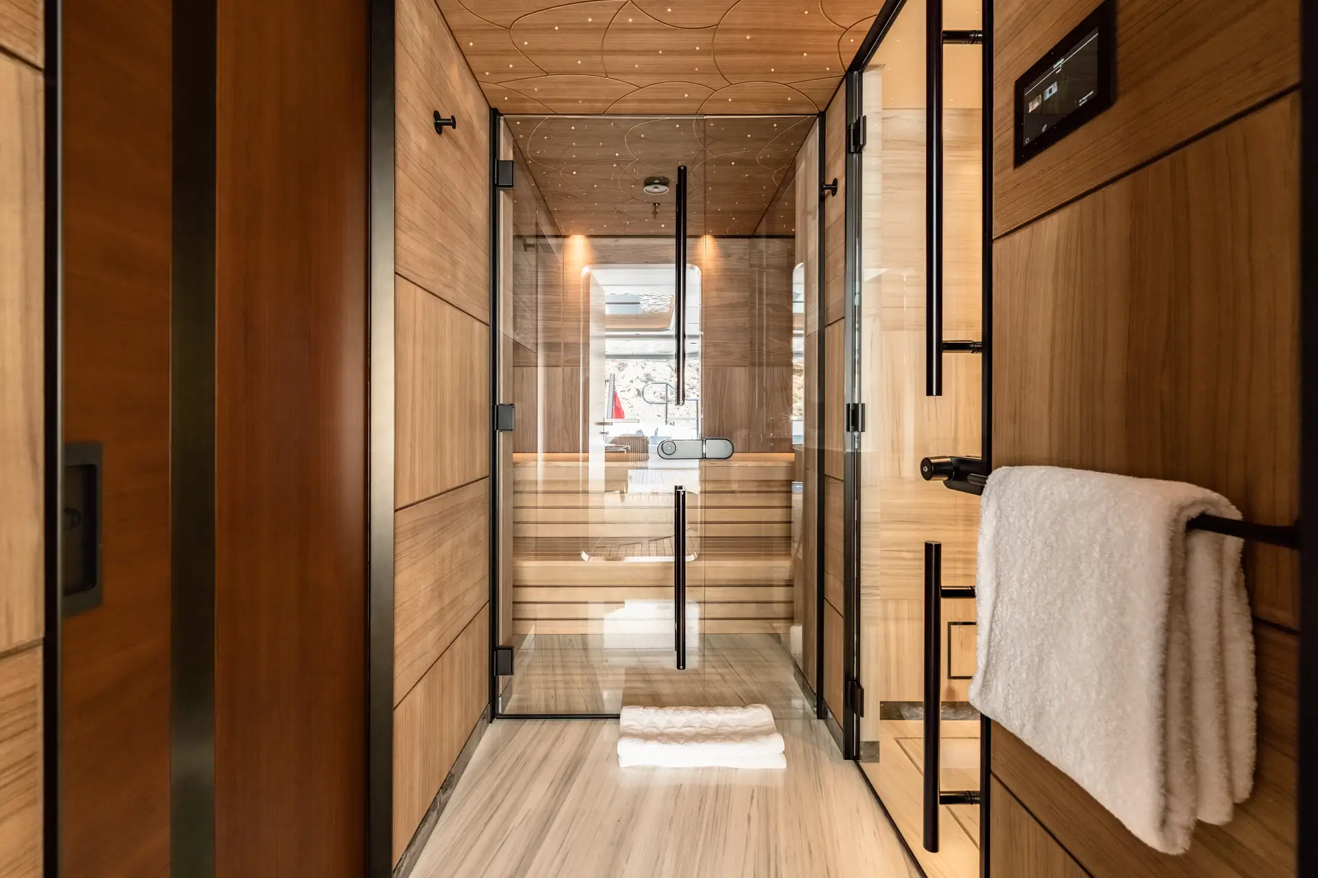Timber-lined spa passage with sauna glazing and warm indirect lighting