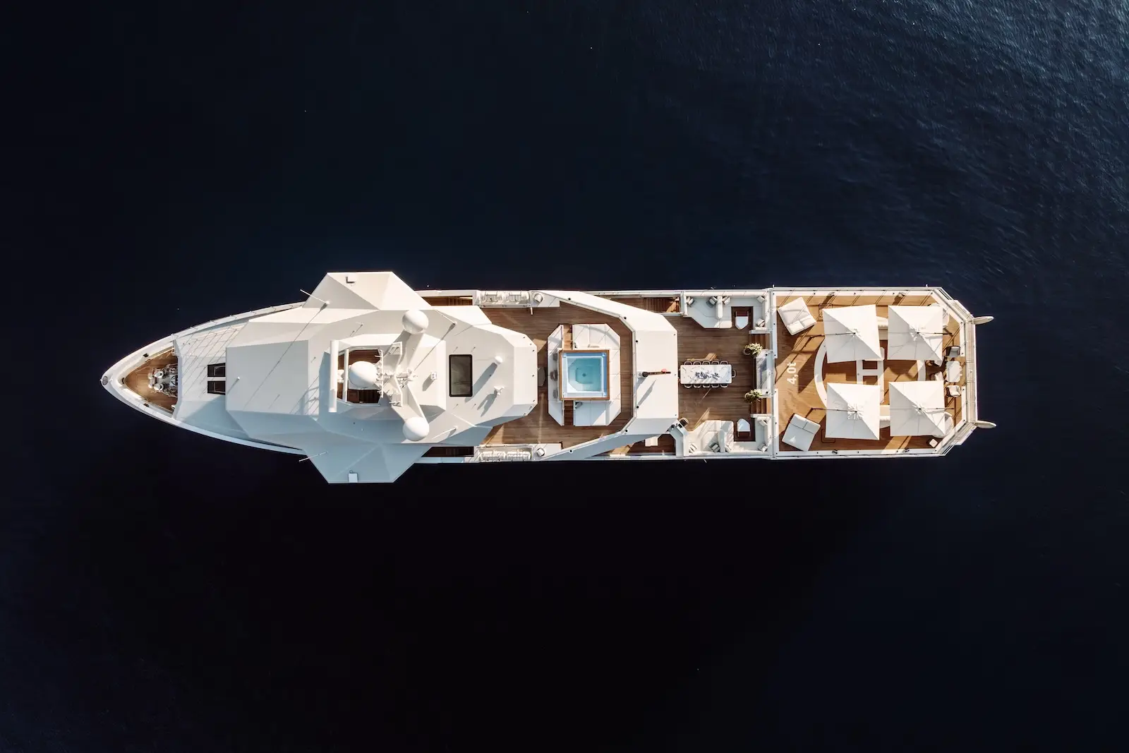 Strict top-down drone view of AFTER YOU in near-black water