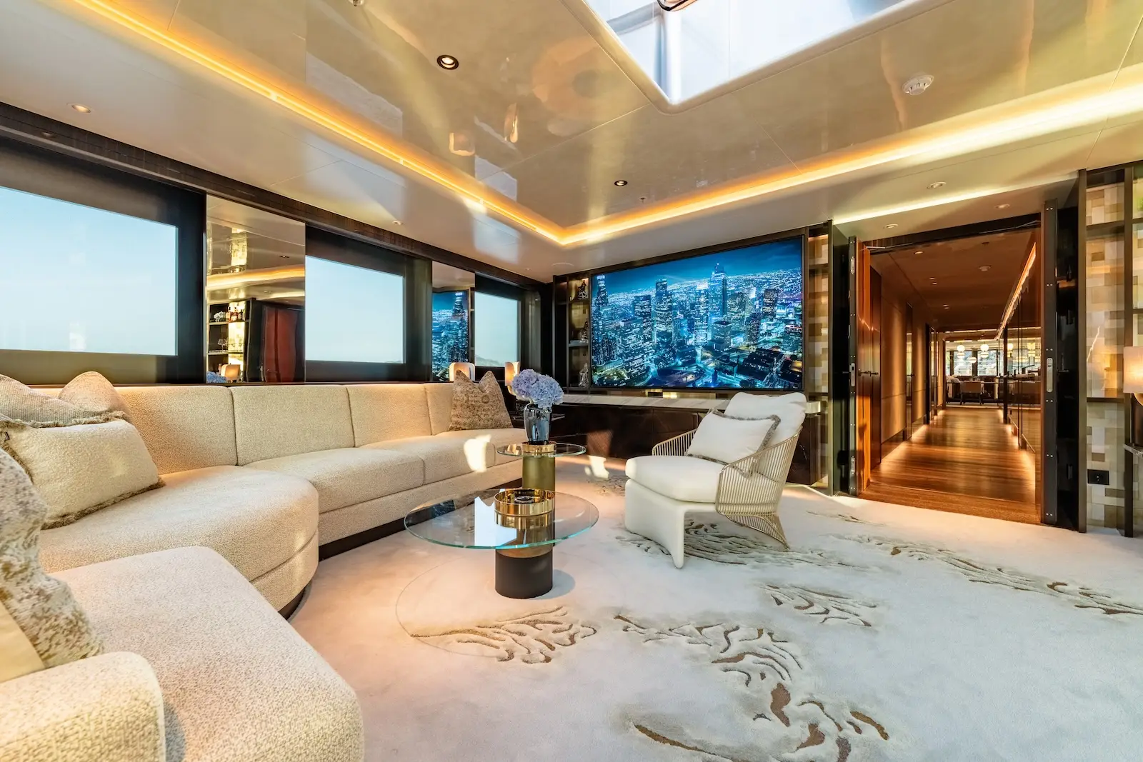 Main salon, pale timber and soft neutral upholstery beneath a dark window band